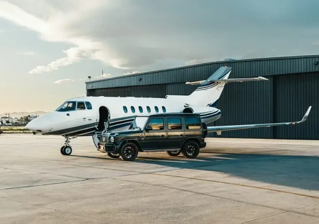 Private jet and black luxury SUV on airport runway for Cannes travel.